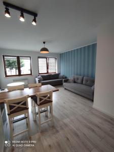 a living room with a table and a couch at Apartament Przy Latarni in Krynica Morska