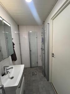 a bathroom with a sink and a shower at Roomvantaa in Vantaa