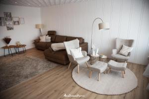 Wipfeld的住宿－Mainblick Apartment，客厅配有沙发和两把椅子