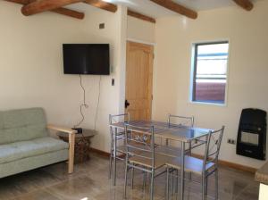 sala de estar con mesa y sofá en Cabañas Barrachina, Punta de Tralca en El Quisco