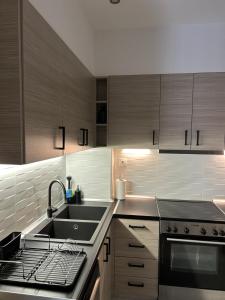 a kitchen with stainless steel appliances and wooden cabinets at Athens Acropolis cozy apartment in Athens