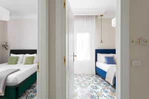 two beds in a room with white and blue at Experience Boutique Hotel - Villa Cimmino in Castellammare di Stabia