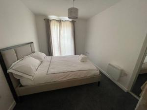 a bedroom with a bed with white sheets and a window at Stunning Cozy Flat 2. in Belvedere