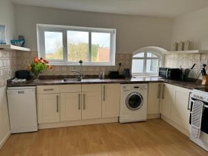 a kitchen with a sink and a washing machine at Mulberry Lawn Apartments in Brading