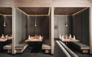 une salle à manger avec deux tables et deux miroirs dans l'établissement Sporthotel Bachmann, à Gargellen