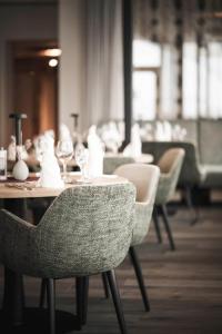 a dining room with a table with chairs and wine glasses at Sporthotel Bachmann in Gargellen