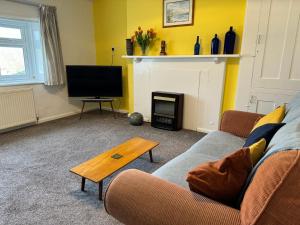 a living room with a couch and a fire place at Mulberry Lawn Apartments in Brading