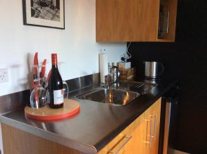 a kitchen counter with a sink and a bottle of wine at The Alpine Retreat in Queenstown