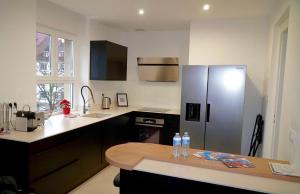 a kitchen with a stainless steel refrigerator and a table at * Hammam * Superbe Appartement * Neudorf in Strasbourg