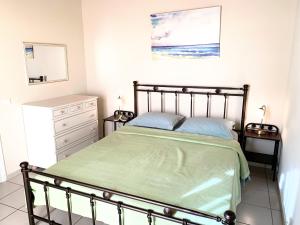 1 dormitorio con 1 cama con colcha verde en ARETOUSA, en Agia Pelagia - Citera