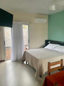 a bedroom with a bed and a large window at Indalo in Termas del Daymán