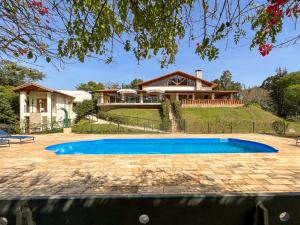 a house with a swimming pool in front of a house at Gardenian Boutique Hotel in São Roque