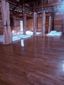 a room with a row of mattresses on a wooden floor at Homestay Mạnh Châu in An Pon