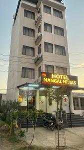 un hotel con un cartel frente a un edificio en Hotel Mangal Niwas en Bedla