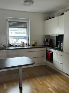 a kitchen with white cabinets and a table in it at Beautiful apartment for you in Ulm