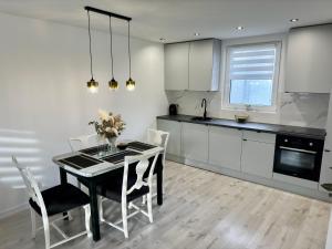 a kitchen with a dining room table and chairs at Apartamenty Kowalska III in Kościerzyna +6 photos