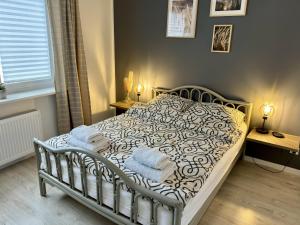 a bedroom with a bed with towels on it at Apartamenty Kowalska III in Kościerzyna