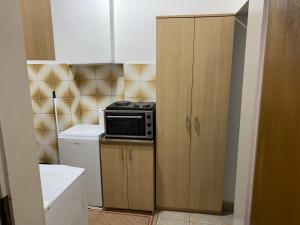 een kleine keuken met een magnetron en een kast bij Center Studio Apartment Podgorica in Podgorica