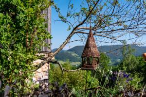 una casa de pájaros colgando de un árbol en un jardín en La Grange d'Hannah - gîte & chambre d’hôtes de charme en Orbey
