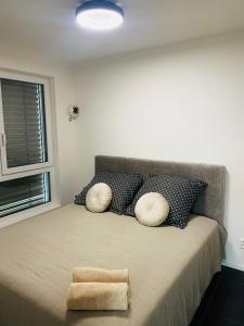 ein Schlafzimmer mit einem Bett mit Kissen und einem Fenster in der Unterkunft Luxusný apartmán v centre in Banská Bystrica