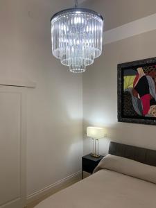a chandelier hanging over a bed in a bedroom at Bari Downtown Luxury Apartment in Bari