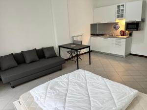 a living room with a couch and a kitchen at Studio mer piscine cala di sole Imperia italie mono locale une seule pièce in Imperia