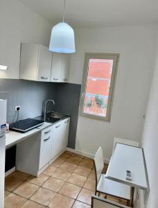 a kitchen with white cabinets and a sink and a window at Casa vacanze Manzoni 289 in Perugia