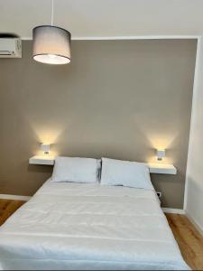 Cama en habitación con 2 almohadas blancas en Casa vacanze Manzoni 289, en Perugia