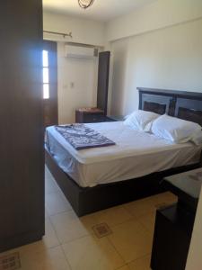 1 dormitorio con 1 cama grande con sábanas blancas en شقة مفروشة لك وحدك قريبة من مكتبة الاسكندرية, en Alejandría