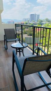 a balcony with a table and a bench on a balcony at Entire Beautiful condo with rooftop pool and gym in Colonia San Benito