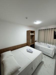 um quarto com 2 camas e uma janela em Hotel Mãe Morena em Aparecida