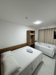 a bedroom with two beds and a window at Hotel Mãe Morena in Aparecida +27 photos