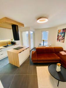 a living room with a couch and a kitchen at Luxusný apartmán v centre in Banská Bystrica