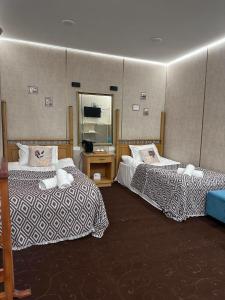 a hotel room with two beds and a mirror at Yongogsoy Village in Kyzyldzhar