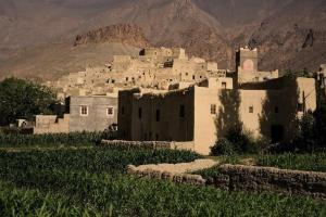 a village in a field with mountains in the background at Auberge Palacio Sidi Hamza in Tazrouft