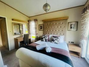 a bedroom with a large bed with two towels on it at Rosie's Rest With Hot Tub in Barmby on the Moor