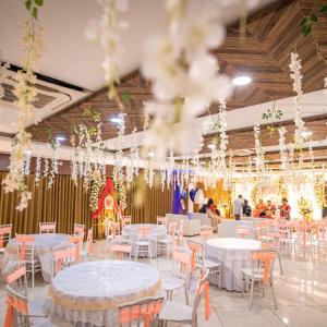 a banquet hall with tables and chairs and chandeliers at Hotel Central Plaza in Siliguri