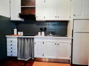 a kitchen with white cabinets and a sink at Mansarda in centro Menaggio con spiaggia privata e possibilità garage in Menaggio