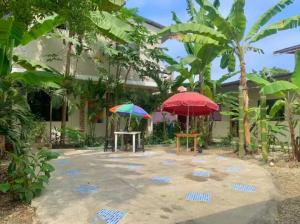 a patio with two umbrellas in front of a house at Casa París “Tropical” in Montañita
