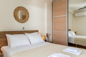a bedroom with a large bed and a mirror at Amazing sea view apartment in Lagonissi in Kalívia Thorikoú