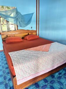 1 dormitorio con 2 camas de madera y almohadas rojas en Happy bangalow riverside, en Muang Không