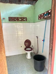 a small bathroom with a toilet and a bucket at Happy bangalow riverside in Muang Không