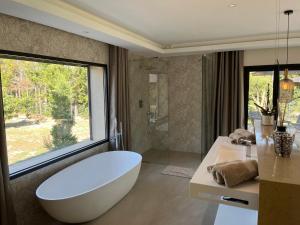 ein Badezimmer mit einer großen Badewanne und einem großen Fenster in der Unterkunft Domaine de La Franquette by Bridget & Pascal in Caderousse