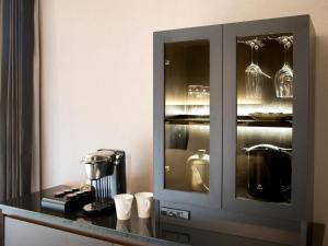 a kitchen with a cabinet with cups on a counter at The Royal Park Hotel Iconic Tokyo Shiodome in Tokyo