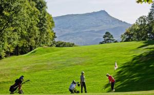 un grupo de personas jugando al golf en una colina verde exuberante en Golfetmer, en San Juan de Luz
