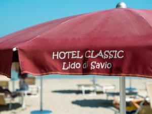 einen roten Regenschirm mit den Worten Hotel classico lido of sauvaho in der Unterkunft Hotel Classic in Lido di Savio