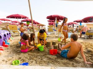 un grupo de niños jugando en la arena en la playa en Hotel Classic, en Lido di Savio