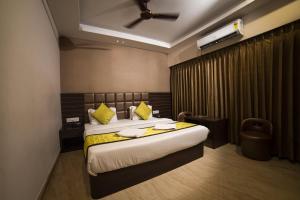 a bedroom with a large bed with yellow pillows at Hotel Central Plaza in Siliguri +43 photos