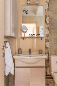 a bathroom with a sink and a mirror at Amazing sea view apartment in Lagonissi in Kalívia Thorikoú +13 photos