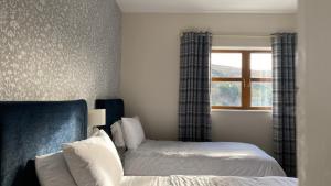 um quarto com 2 camas e uma janela em Drop Anchor Guesthouse em Cleggan